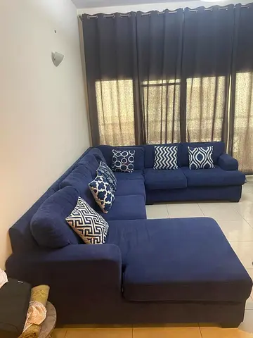 Large U- shaped navy blue fabric sectional sofa with dining table