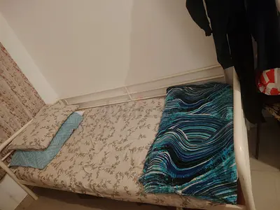 Single white metal bed frame with mattress and bedding - good condition