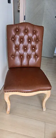 Brown tufted leather dining chair with wooden legs