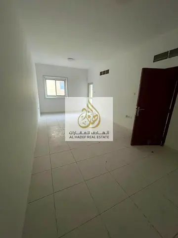 Spacious one-bedroom apartment with a separate living room, two bathrooms, and built-in wardrobes, located in Al Rashidiya 3.