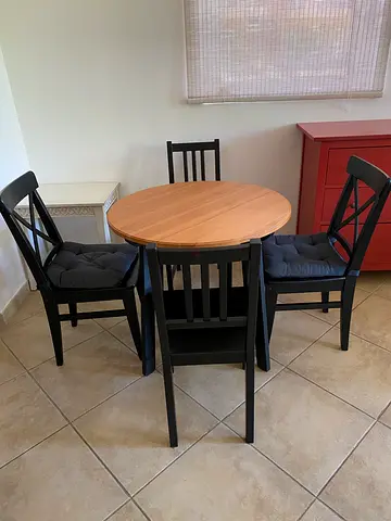 Wooden round dining table with 4 black cushioned chairs - good condition