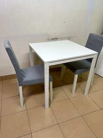 White IKEA-style 2-seater dining table with 2 grey upholstered chairs