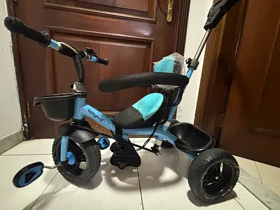 Lightweight blue toddler tricycle with push handle and safety bar