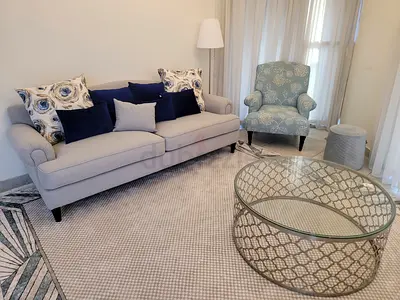 Light grey 3-seater sofa with cushions and matching armchair and glass table and carpet