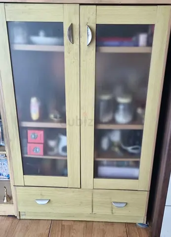 Light green kitchen/storage cabinet with frosted glass doors and drawers