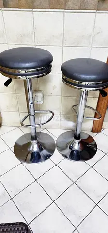 Pair of adjustable chrome bar stools with black seats