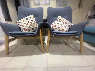 Pair of modern blue fabric lounge chairs with wooden legs