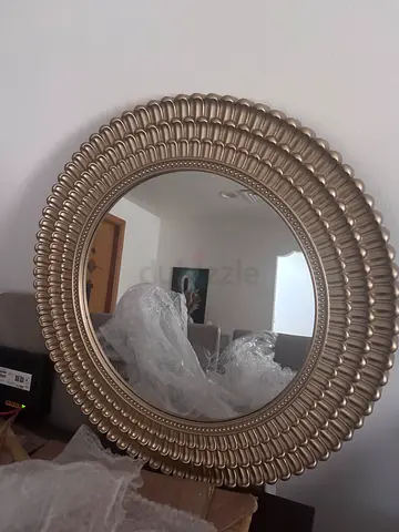 Decorative round wall mirror with ornate gold frame