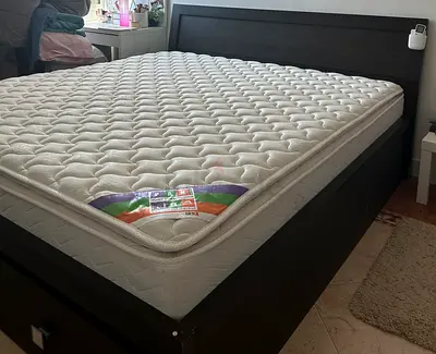 queen-size bed with mattress and two built-in storage drawers.