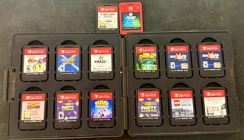 Collection of 14 Nintendo Switch game cartridges with storage case