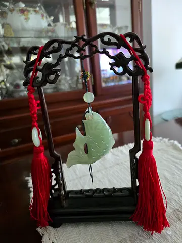 Beautiful, hand-carved Chinese jade/stone pendant depicting an auspicious fish, presented as a table