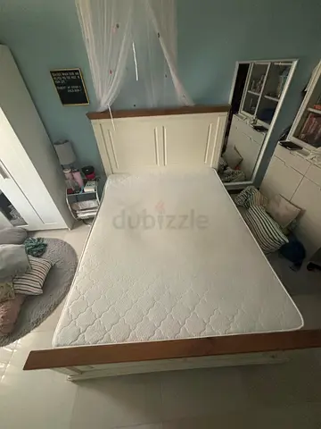 Sleek white wooden bed with new mattress