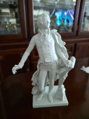 This striking sculpture features the legendary composer Wolfgang Amadeus Mozart standing dramaticall