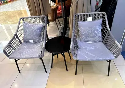 Pair of grey rattan-style outdoor/lounge chairs with small side table
