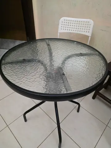 Small round glass-top bistro table with metal frame