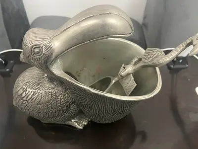 Decorative metal toucan-shaped serving bowl with matching spoon
