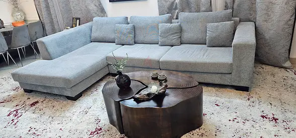 Light grey L-shaped fabric sofa with chaise and cushions - good condition