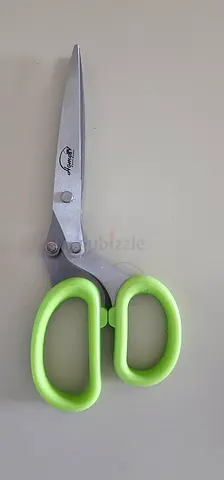 Large household scissors with green grip for cutting herbs