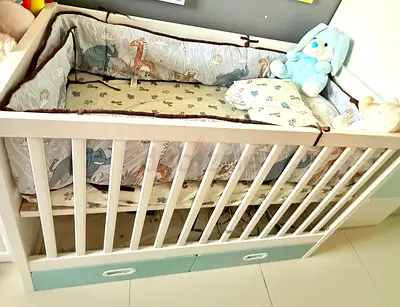 White wooden baby crib with storage drawers — hardly used