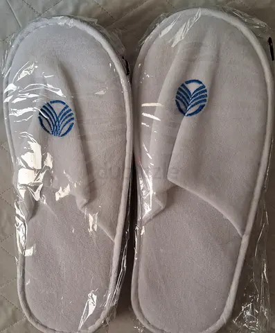 Pair of white hotel-style disposable slippers (unused) one for men , one for women