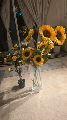 Set of artificial sunflowers in clear glass vase