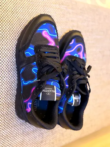 Valentino  sneakers feature a vibrant neon camouflage pattern in blue and purple