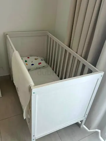 White wooden baby crib in good condition with mattress