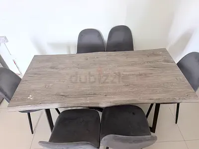 6-seater dining table with grey wood top and velvet chairs