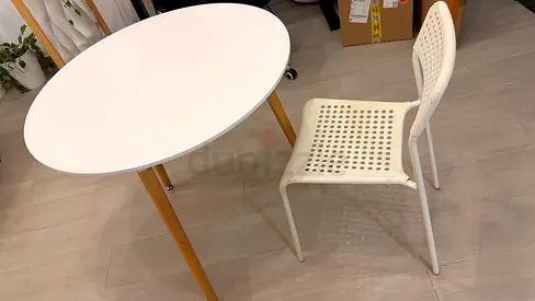 Small round dining table with wooden legs and white chair