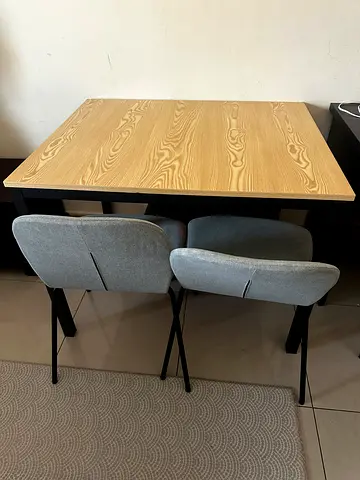 Wooden dining table with two grey upholstered chairs - good condition