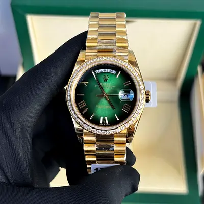 This Rolex Day-Date 40 in 18K yellow gold features a distinctive green ombré d