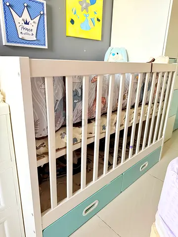 White wooden baby crib with storage drawers — hardly used