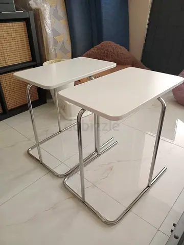 Pair of white C-shaped side tables with chrome legs