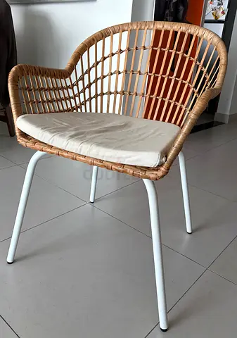 Rattan-style dining/occasional chair with white cushion and metal legs