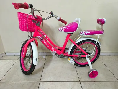 Pink girls' 14-inch bike with training wheels and basket - good condition