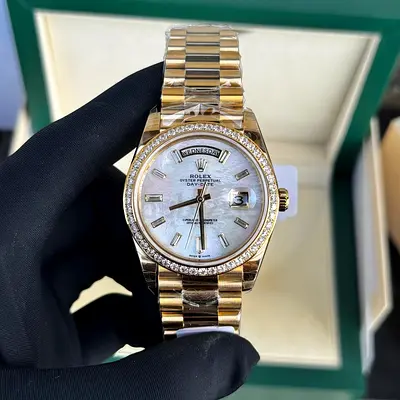 This appears to be a Rolex Day-Date 40 in yellow gold with a white mother-of-pearl dial and diamond-