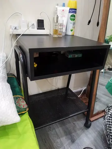 Black metal bedside table with shelf and drawer-style cubby