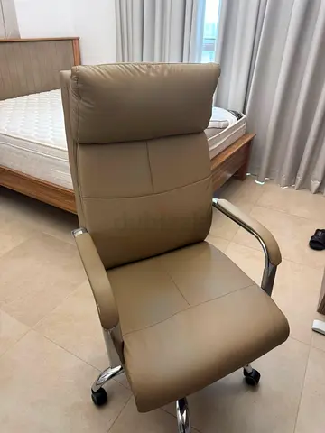 Beige High-Back Office Chair with Headrest and Chrome Base