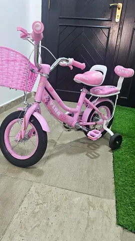 Kids pink 12-inch bike with training wheels and basket - good condition