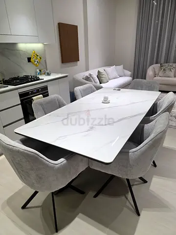 Modern white marble-effect dining table with 6 grey upholstered chairs