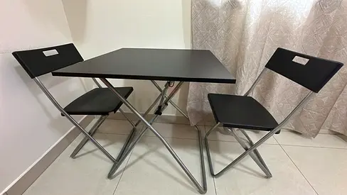 Compact black folding dining table with two matching chairs — good condition