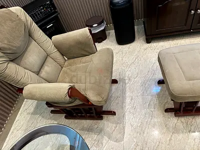 Beige upholstered glider rocking recliner chair with matching footstool