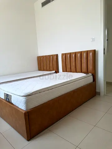 Two single leather beds with storage drawers underneath.