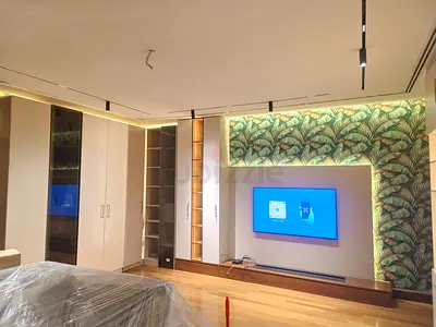 Modern built-in bedroom wardrobe and media wall with LED lighting