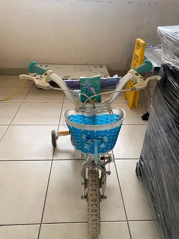 Children's blue bike with training wheels and front basket