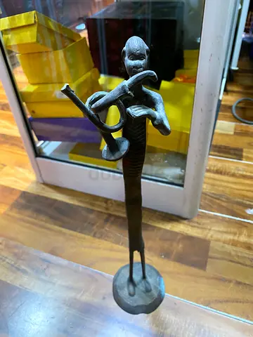 Antique bronze figurine playing horn — tall metal statue
