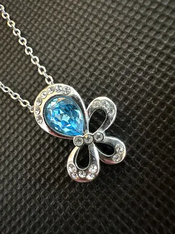 Silver-tone bow pendant with blue teardrop crystal and chain
