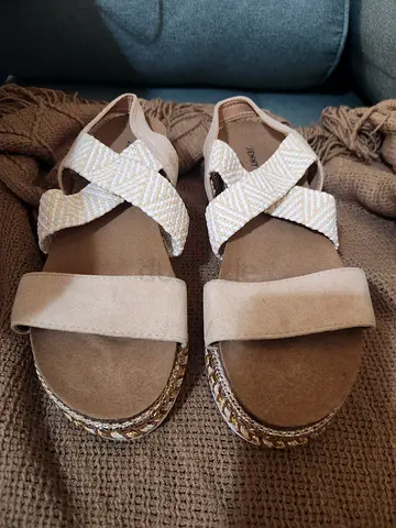 Beige platform sandals with braided ankle straps, size not specified