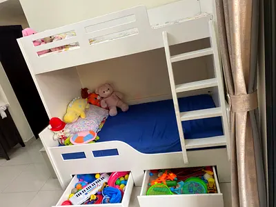 White wooden bunk-style toddler bed with built-in ladder and storage