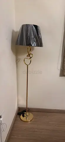 Gold floor lamp with decorative knot and grey shade